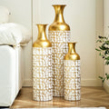 Set of three gold and white metal floor vases